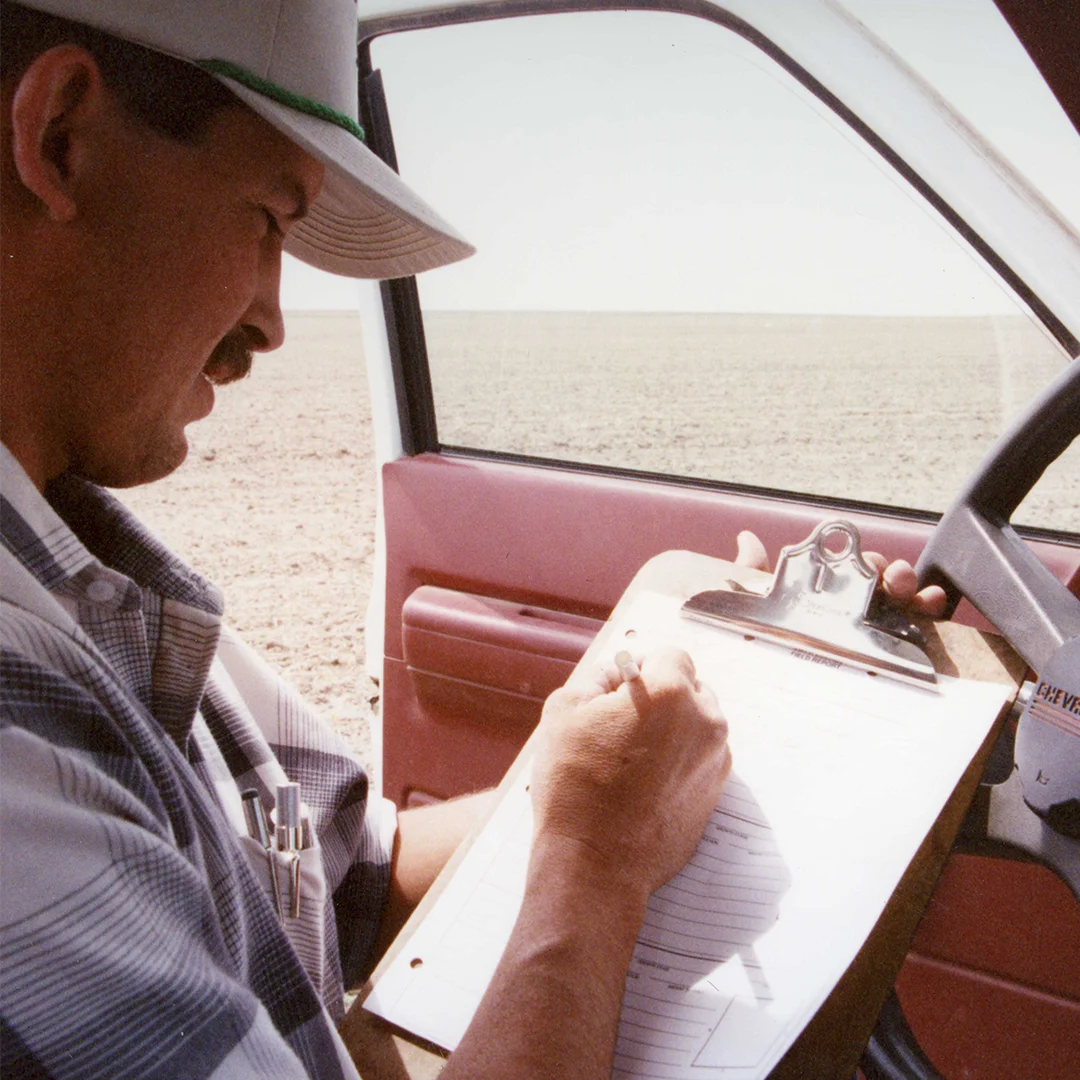 Agronomist writing field notes in truck man sitting in truck taking notes