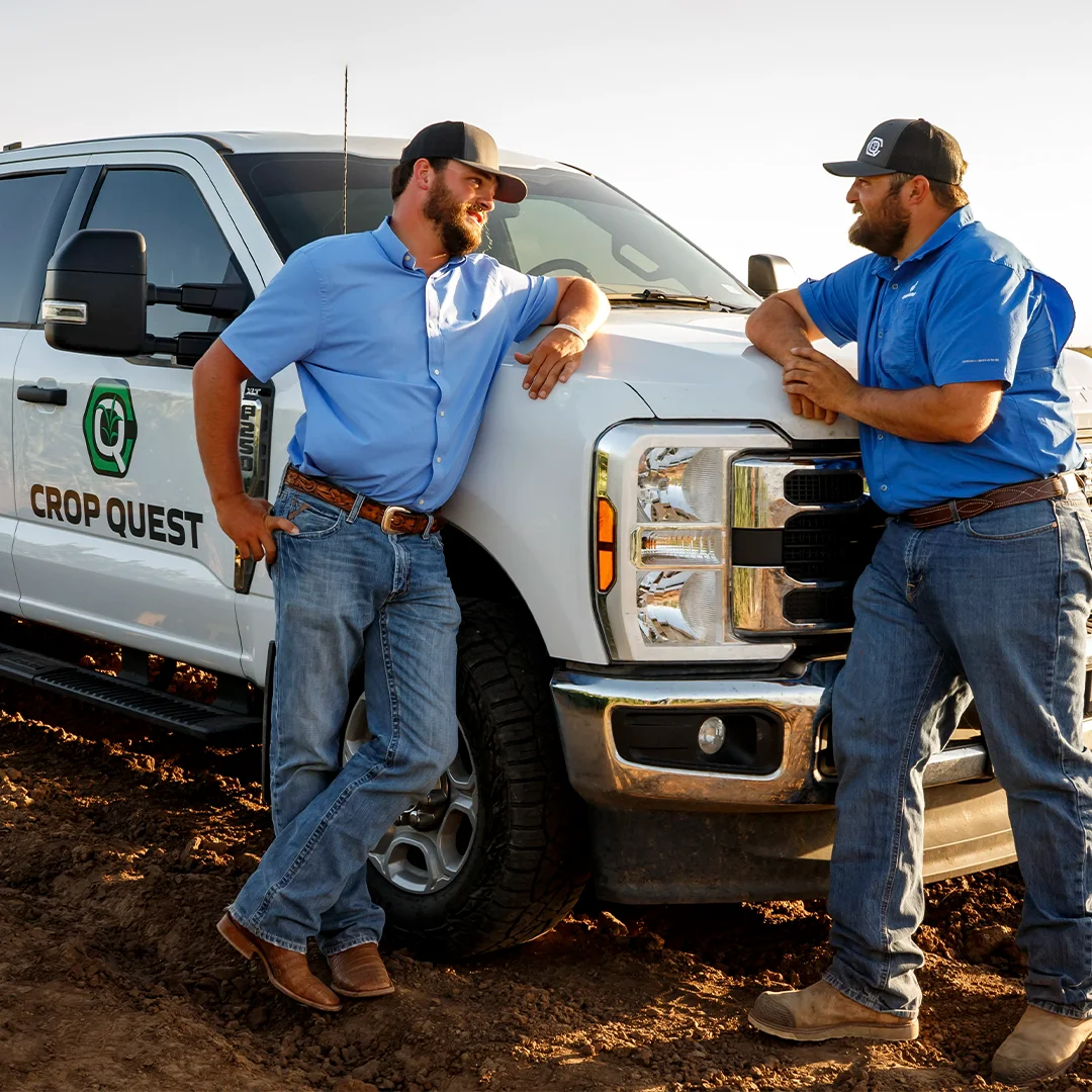 agronomists leaned against truck talking
